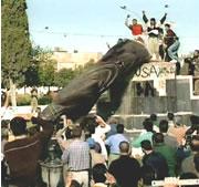 People topple a statue of Saddam Hussein in Iraq.