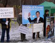 Protestors stand outside the university, standing by Hwang and asking for more time for him to prove his methods.