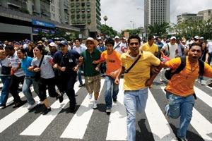 Cutbacks have sparked protests in Caracas against President Hugo Ch&x00E1;vez (inset).
