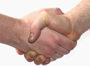 A close-up photograph shows two hands connected in a hand-shake gesture.