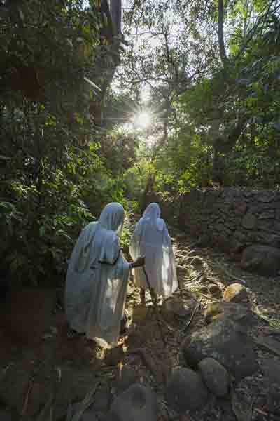 Two women walk towards Betre Mariam church