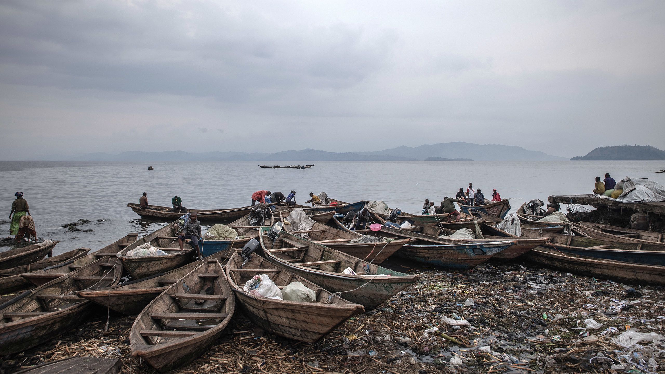 Fishermen and their dugout canoes on the shores of Lake Kivu