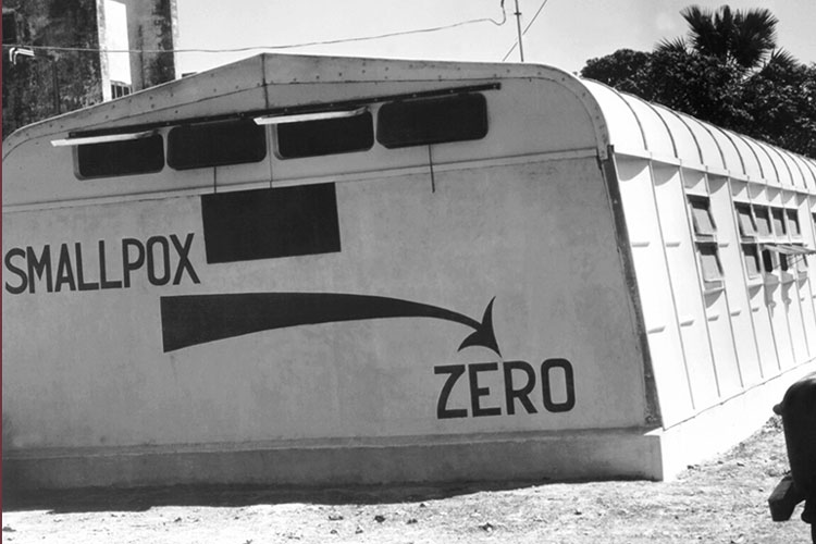 Photograph of a clinic annex building in East Pakistan with graffiti about the goal of eradicating smallpox