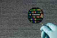 A hand with a blue medical glove is holding a magnifying glass for a computer screen with a gray DNA code.