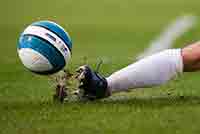 A sliding tackle showing close-up of football and boot.