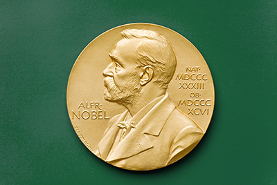 镀金的诺贝尔奖奖章，展示了一个男人（阿尔弗雷德·诺贝尔）头部的侧面视图，留着胡须和短发。 左侧刻有“Alfred Nobel”，右侧刻有罗马数字“1833”和“1896”。
