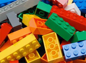 A close-up photograph shows a pile of multicolored Lego building blocks.