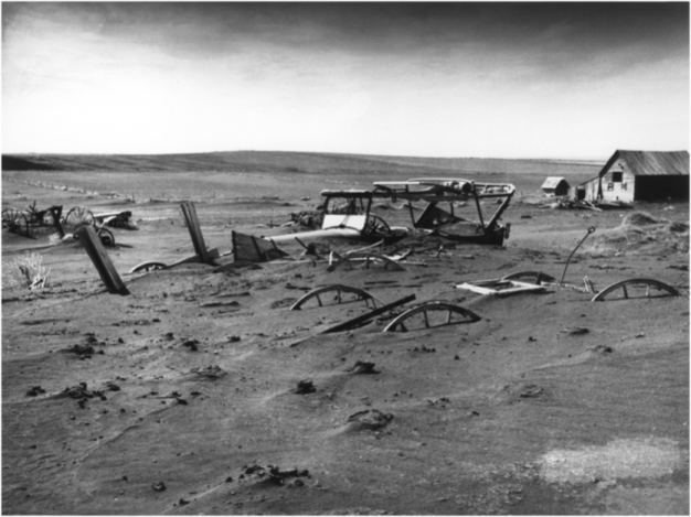 Dallas, South Dakota: tractor and farm equipment buried by soil transported by wind (May 13, 1936).